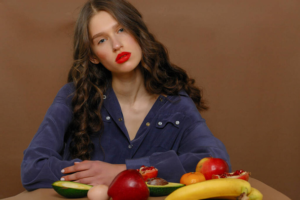 Young woman in group of fruit. Healthcare and healthy nutrition concept. Red lipstick - Фото, зображення