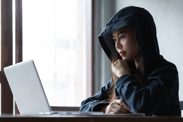 Женщина-хакер из Азии крадет данные из онлайн-компьютерных систем с помощью ноутбука. концепция бизнес-вредоносного ПО и хакера - Фото, изображение