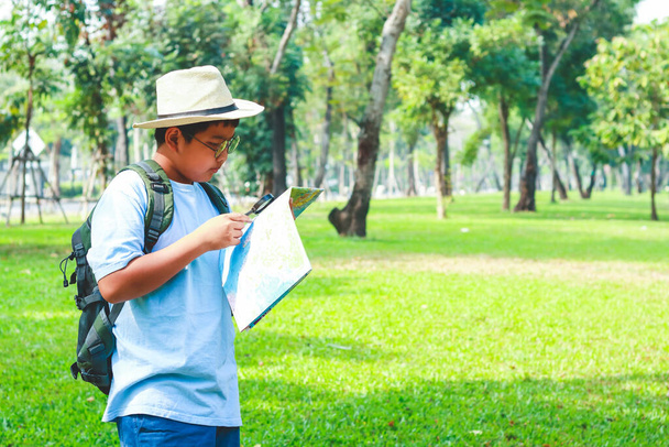 Ασιάτες φοιτητές που κουβαλάνε σακίδιο ταξιδιού, φοράνε καπέλο, κρατούν ένα χάρτη για να ταξιδέψουν για να μάθουν - Φωτογραφία, εικόνα