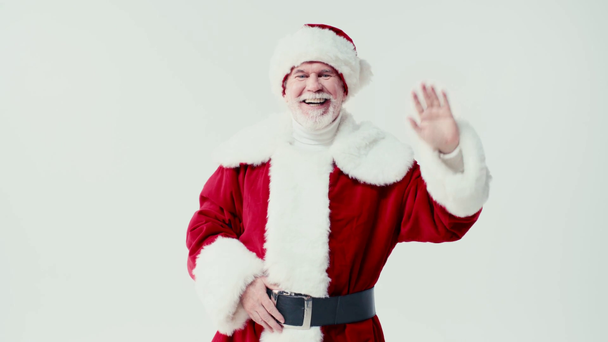 cheerful santa claus waving hand and smiling at camera isolated on white - Felvétel, videó