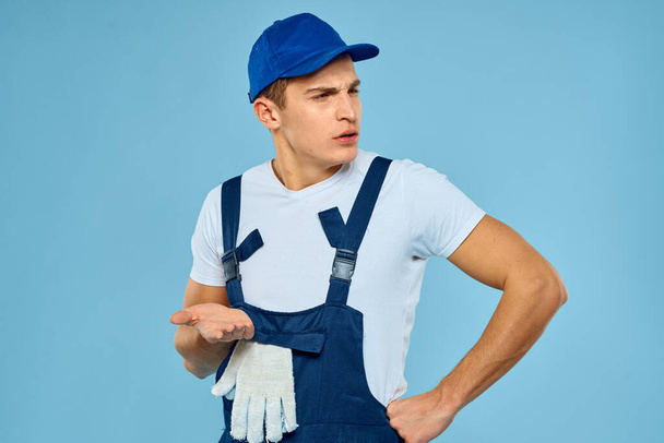 Рабочий в форме погрузчика перчаток, оказание услуг синего фона - Фото, изображение