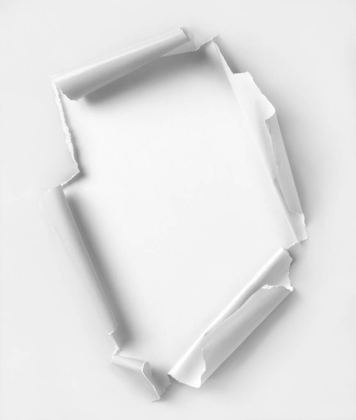 Agujero rasgado papel de color blanco. Fondo blanco. Recorte camino dentro del agujero - Foto, Imagen