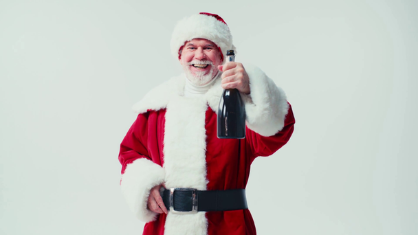 веселый Санта Клаус показывает бутылку шампанского на камеру изолированы на белом - Кадры, видео