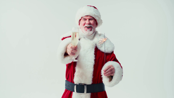χαρούμενη Santa Claus κρατώντας ποτήρι σαμπάνιας και sparkler απομονώνονται σε λευκό - Πλάνα, βίντεο