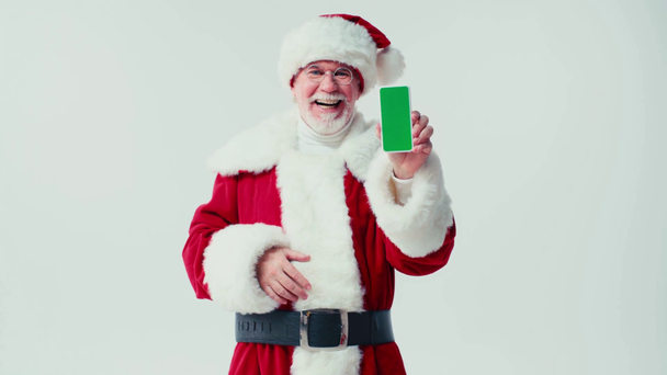 sorridente Babbo Natale che mostra il telefono cellulare con schermo verde isolato su bianco - Filmati, video