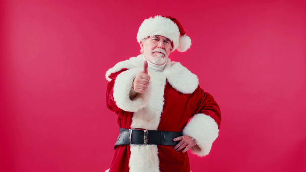Άγιος Βασίλης δείχνει τον αντίχειρα προς τα πάνω και γνέφει το κεφάλι απομονώνονται στο κόκκινο - Πλάνα, βίντεο