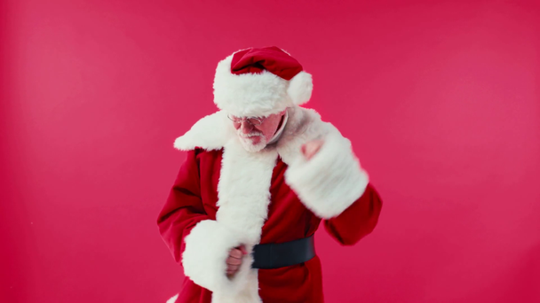 cheerful santa claus in eyeglasses dancing isolated on red - Felvétel, videó