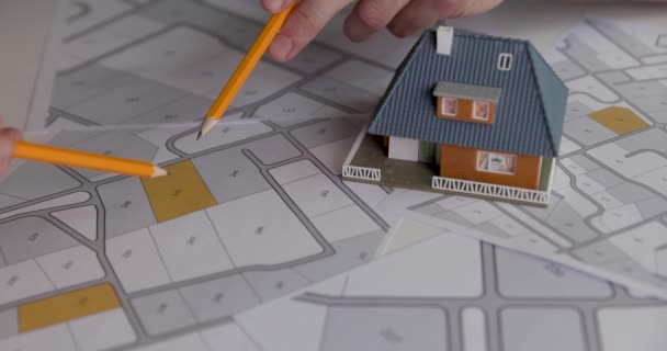 persone discutendo e scegliendo terreno edificabile per la costruzione di case sulla mappa catastale - Filmati, video