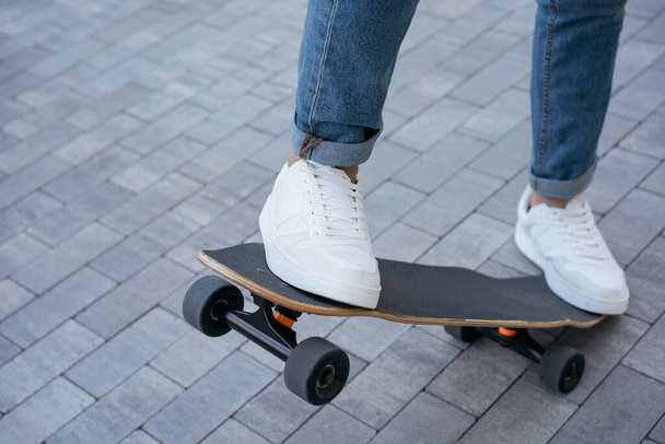 Man riding on a skateboard on urban street, practice skateboarding trick. Extreme sport, active lifestyle concept - Fotó, kép