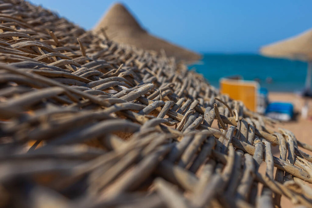 Großaufnahme von Sonnenschirmen aus trockenen Palmblättern am Strand - Foto, Bild