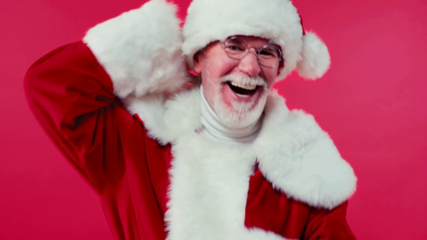 vreugdevolle kerstman dansen op camera geïsoleerd op rood - Video