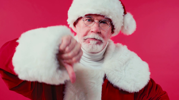 displeased santa claus showing thumb down isolated on red - Materiał filmowy, wideo