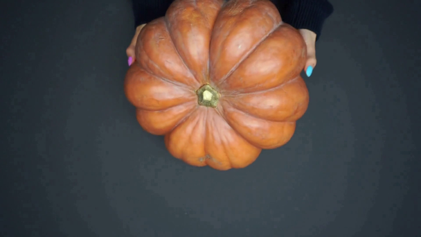 top view of woman replacing carved pumpkin on black, halloween concept - Footage, Video
