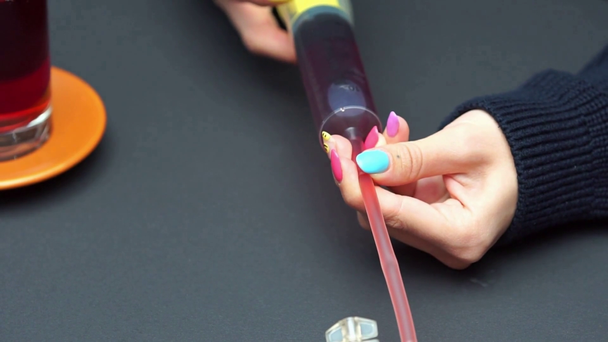 Widok kobiety napełniającej opakowanie krwi płynem ze strzykawki ze słodyczami - Materiał filmowy, wideo