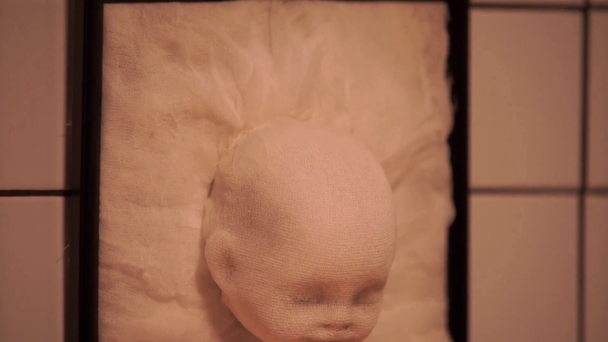 inquietante e finta testa di bambino in cornice appesa al muro, concetto di Halloween - Filmati, video