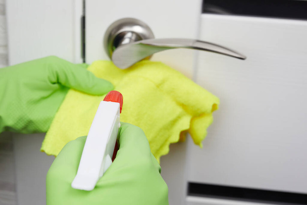 Weibliche Hände desinfizieren, reinigen und waschen Türklinken. Prävention von Coronavirus-Infektionen während der COVID-19. Weiße Tür. - Foto, Bild