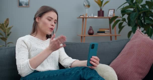 Crop view of woman with hearing loss communicating on smartphone and usign sign language.Smiling female person having video call and showing with finger spelling phrase Go for coffee. - Imágenes, Vídeo