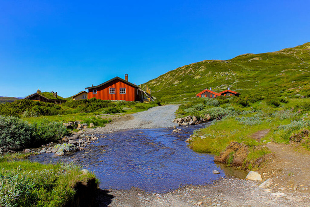 Red Norwegian huts on Vavatn lake and river in Hemsedal, Norway. - Photo, image