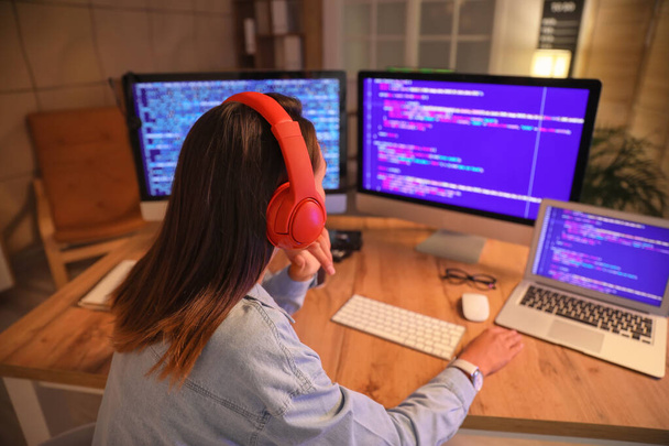 Programadora femenina trabajando en la oficina por la noche - Foto, Imagen