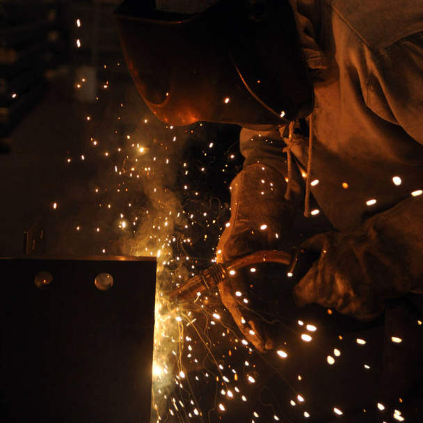 Welder assembling technical steel. Industrial welding of metal structures at the plant - Фото, зображення