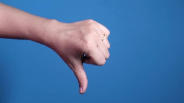 ruka ukazující palec dolů znamení na modrém pozadí. - Záběry, video