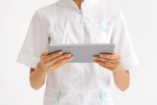 lékařské pojetí. oříznutý nepoznatelný lékař drží tablet bezdrátový počítač na bílém pozadí - Fotografie, Obrázek
