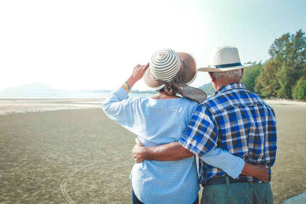 Starší asijský pár, jak stojí a objímají se na pláži a vidí večerní světlo. Koncept starší společnosti - Fotografie, Obrázek