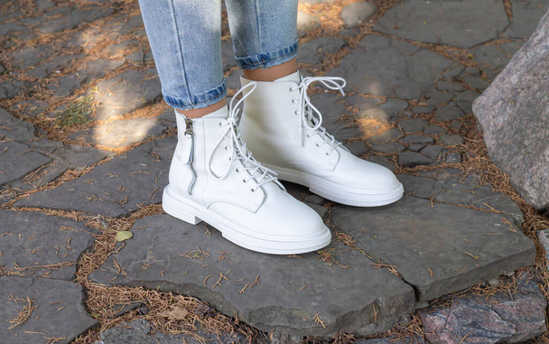 Женские ноги в белых модных сапогах со шнурками - Фото, изображение