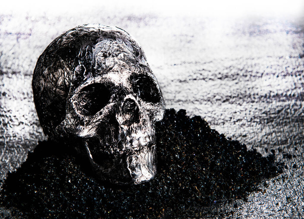 srebrna czaszka na czarnym piasku - Zdjęcie, obraz