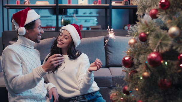 heureux couple afro-américain tenant des étincelles près de l'arbre de Noël - Séquence, vidéo