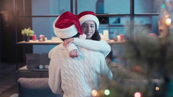 szczęśliwy afrykański amerykański para w Santa kapelusze taniec w domu - Materiał filmowy, wideo
