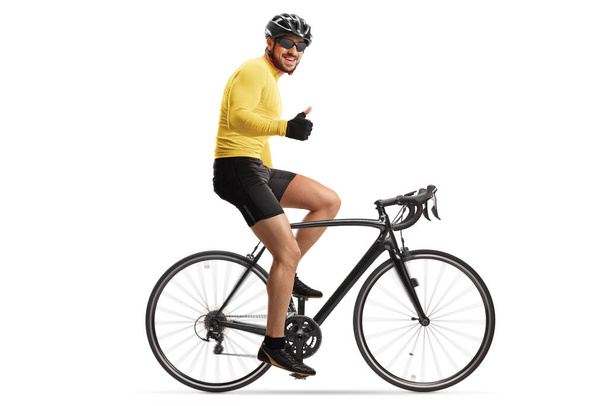 Male cyclist with a helmet riding a road bicycle and showing thumbs up isolated on white background - Foto, afbeelding