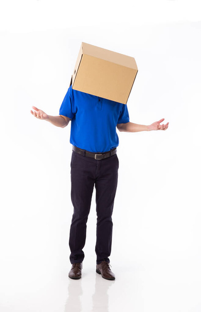 man in a bluer T-shirt with a cardboard box on his head makes a gesture with his hands isolated on white background - Fotoğraf, Görsel