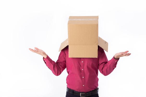 man in a red shirt with a cardboard box on his head makes a gesture with his hands isolated on white background - Фото, зображення