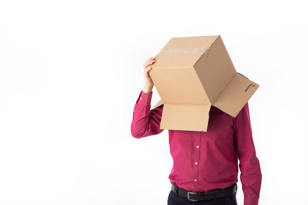 Человек в красной рубашке с картонной коробкой на голове делает жест с руками изолированы на белом фоне - Фото, изображение