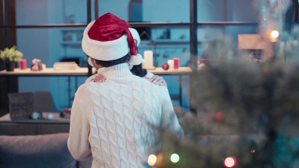 joyful african american couple in santa hats dancing at home - Materiał filmowy, wideo