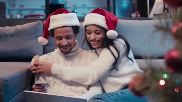 felice coppia afro-americana in cappelli Santa shopping online  - Filmati, video