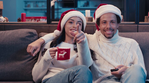 happy african american couple watching movie on christmas  - Filmati, video