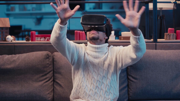 afro-americano em realidade virtual headset gesticulando em casa - Filmagem, Vídeo