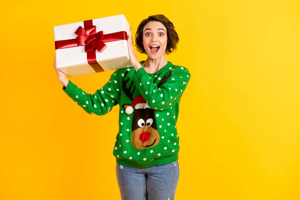 Photo excited astonished crazy girl in funky reindeer pullover sweater get gift box x-mas christmas time magic spirit atmosphere event isolated bright shine color background - Фото, изображение