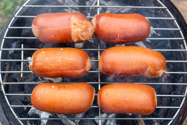 крупним планом гриль для барбекю з м'ясом та ковбасками, які готують під час літньої вечірки в саду
 - Фото, зображення