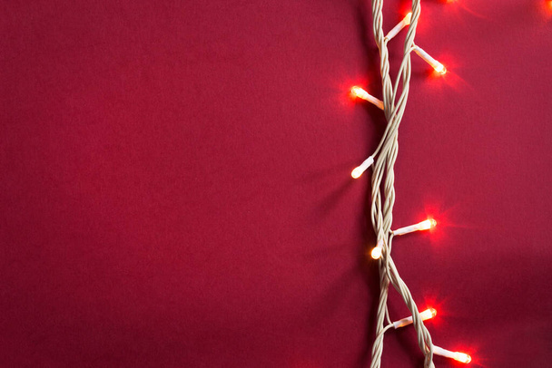 Led lights decorative garland on red background closeup - Foto, afbeelding