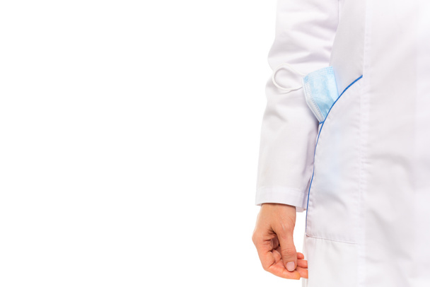 Vista ritagliata del medico in cappotto bianco con maschera medica in tasca isolata su bianco - Foto, immagini