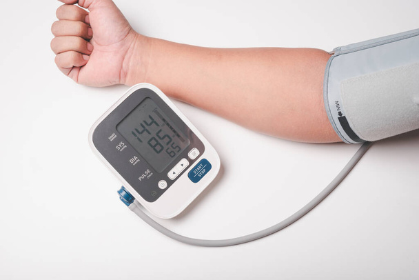 man hand using digital pressure gauge check his blood pressure , digital number showing hypertension result - Foto, imagen