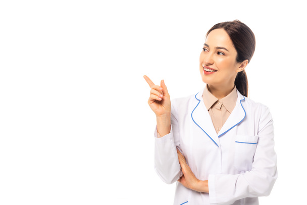 Smiling doctor in white coat pointing with finger isolated on white - Photo, Image