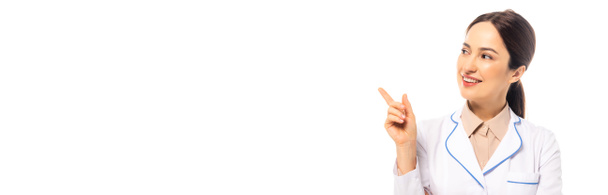 Cultura horizontal de médico alegre apontando com o dedo isolado no branco - Foto, Imagem