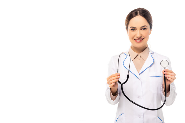 Smiling doctor in white coat holding stethoscope isolated on white - Фото, зображення