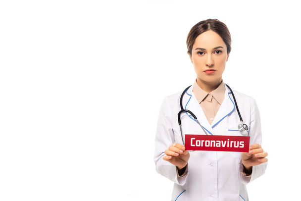 Dokter in witte vacht met coronavirus letters geïsoleerd op wit - Foto, afbeelding