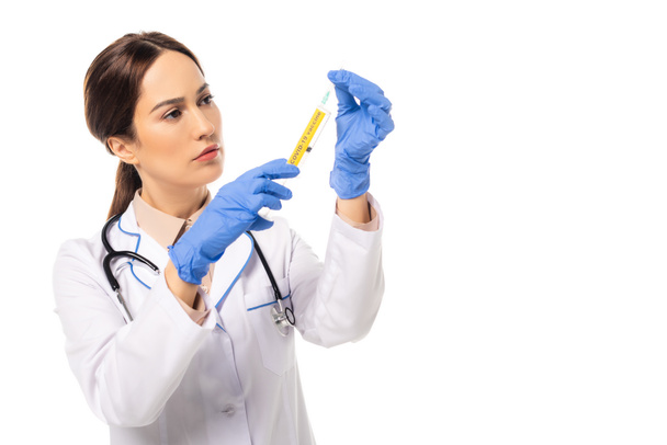 Doctor in latex gloves holding syringe with coronavirus lettering isolated on white - Photo, Image