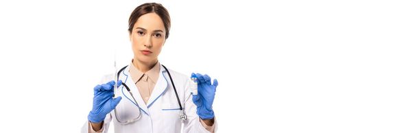 Панорамний знімок лікаря в латексних рукавичках, що тримає вакцину та шприц ізольовані на білому
 - Фото, зображення